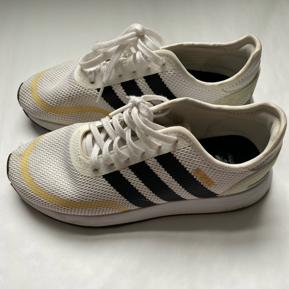 Adidas White Sneakers with Black Stripes and Gold Detail